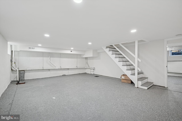 finished basement featuring stairway, recessed lighting, and visible vents