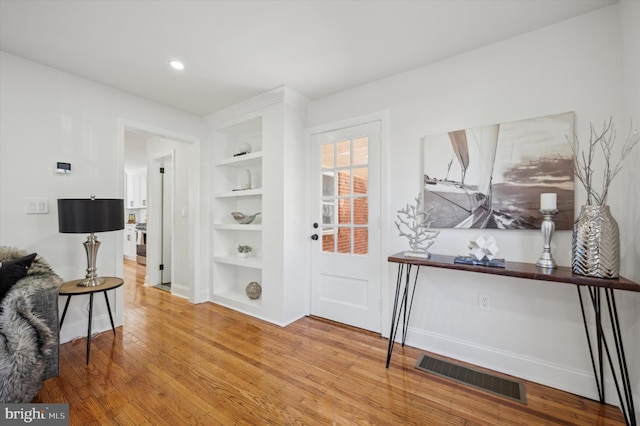 foyer entrance with recessed lighting, visible vents, baseboards, and wood finished floors