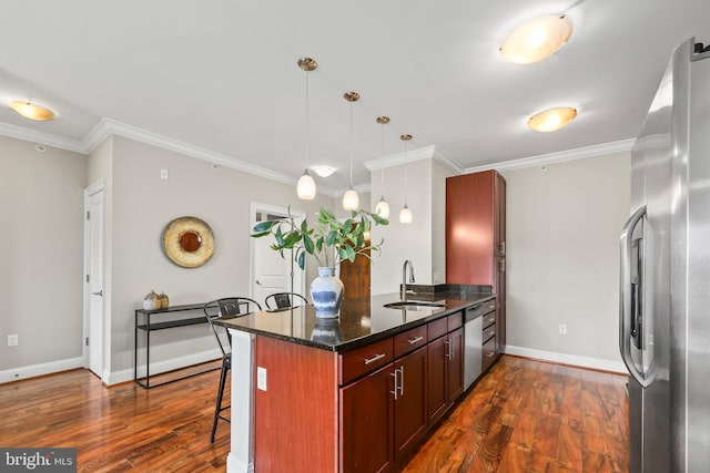 kitchen with sink, a breakfast bar area, hanging light fixtures, stainless steel appliances, and kitchen peninsula