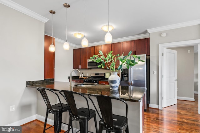 kitchen with pendant lighting, stainless steel appliances, kitchen peninsula, and sink