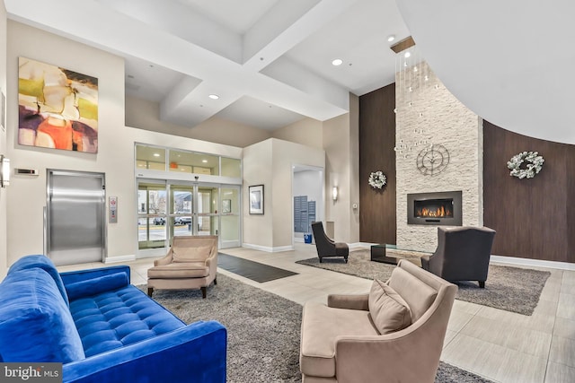 living room featuring a high ceiling, a stone fireplace, elevator, and light tile patterned floors