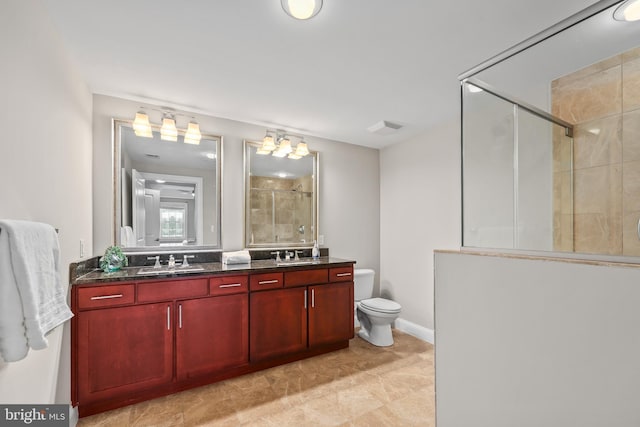 bathroom with a shower with door, vanity, and toilet