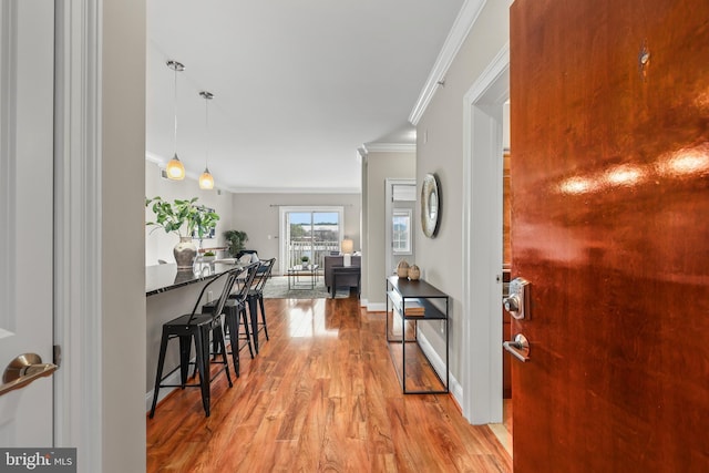 hall with light hardwood / wood-style flooring and ornamental molding