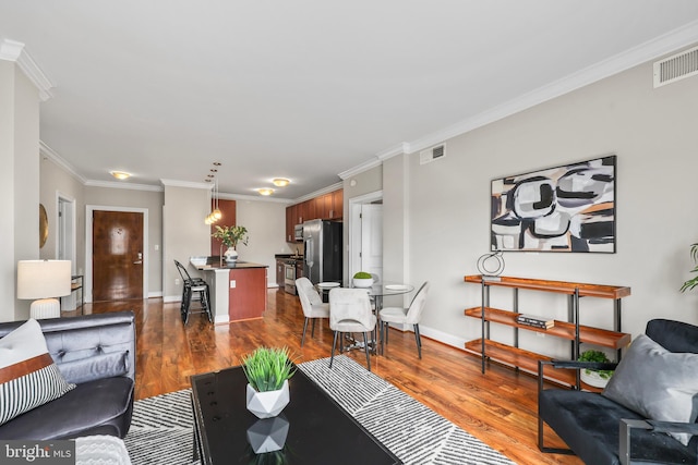 living room with dark wood-type flooring and ornamental molding