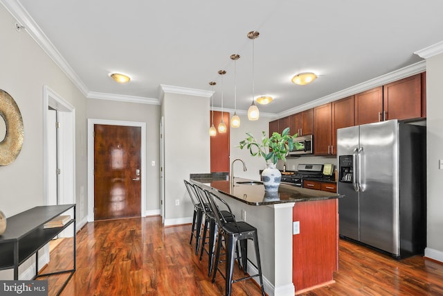 kitchen with pendant lighting, dark wood-type flooring, ornamental molding, and appliances with stainless steel finishes