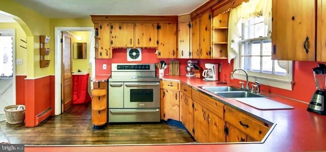 kitchen with range with two ovens, sink, and dark wood-type flooring