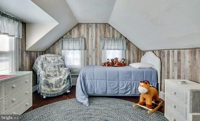 bedroom featuring lofted ceiling, dark hardwood / wood-style floors, and wood walls