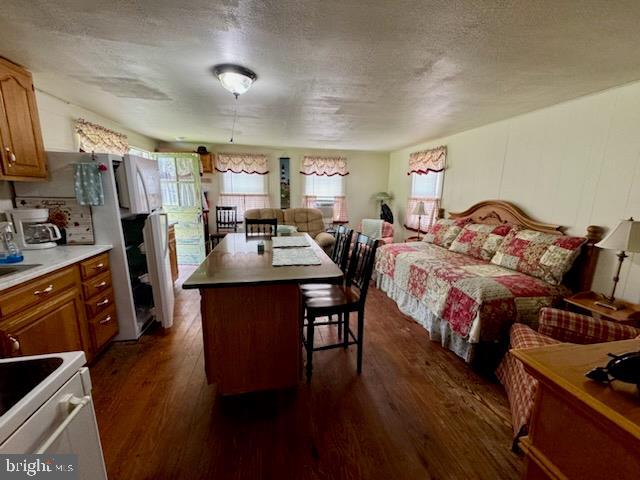 bedroom featuring a textured ceiling and dark hardwood / wood-style flooring