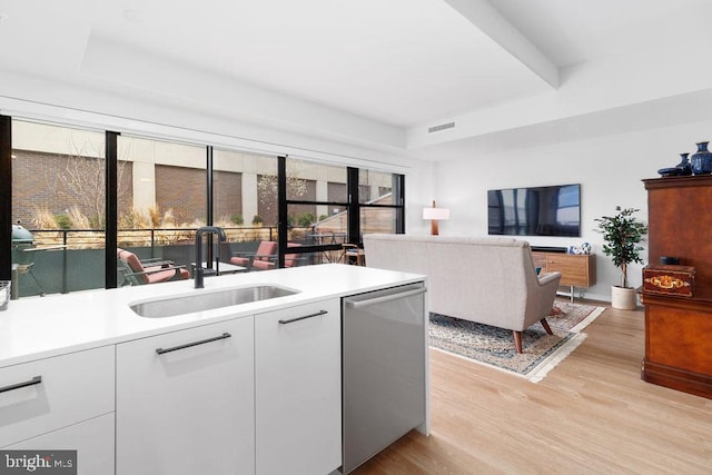 kitchen featuring light hardwood / wood-style floors, sink, dishwasher, and white cabinets