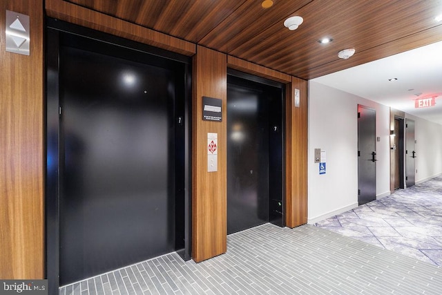 hallway with wood ceiling and elevator