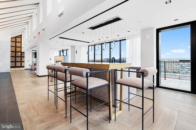 dining room with a wall of windows and light parquet flooring