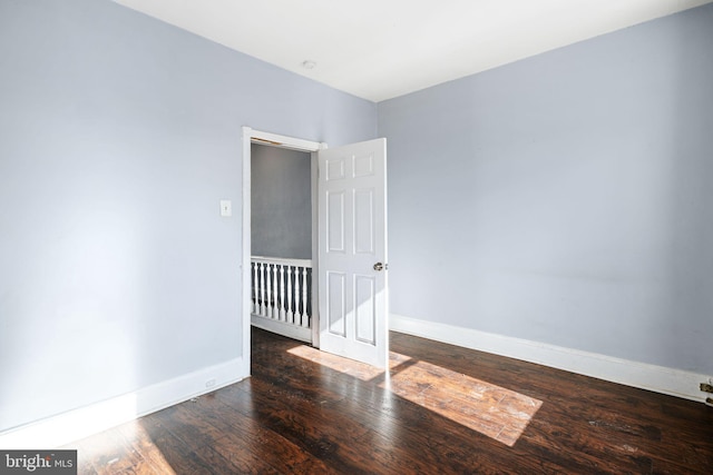 unfurnished room featuring dark wood-type flooring