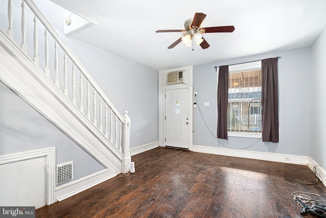 foyer entrance with ceiling fan, wood-type flooring, and a wall mounted AC