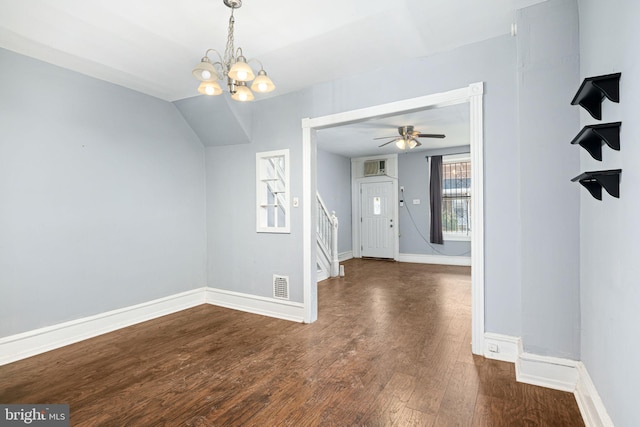 empty room with ceiling fan with notable chandelier and dark hardwood / wood-style floors