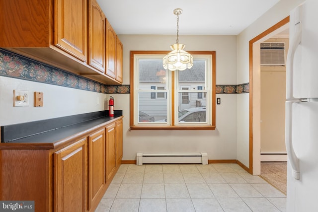 kitchen featuring white fridge, a baseboard heating unit, pendant lighting, and a wall unit AC