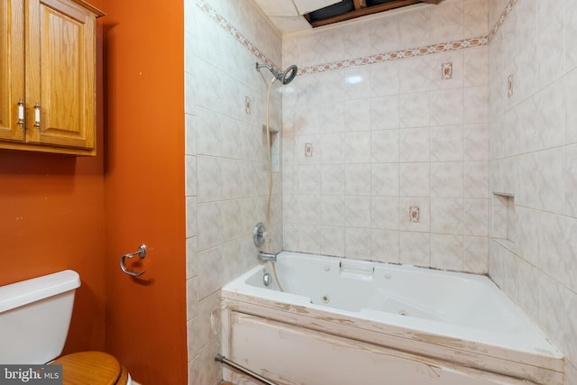 bathroom featuring tiled shower / bath and toilet