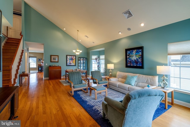 living room with a healthy amount of sunlight, a chandelier, and light hardwood / wood-style flooring