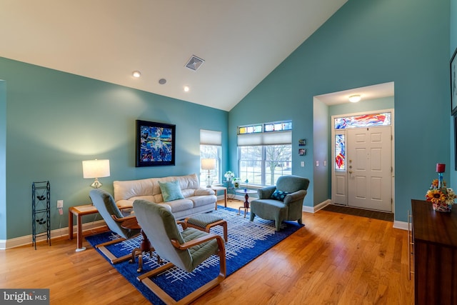 living room with hardwood / wood-style flooring and high vaulted ceiling