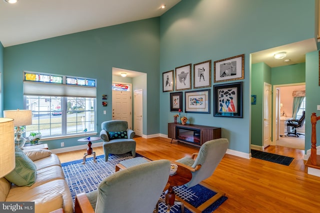 living room with high vaulted ceiling and hardwood / wood-style floors