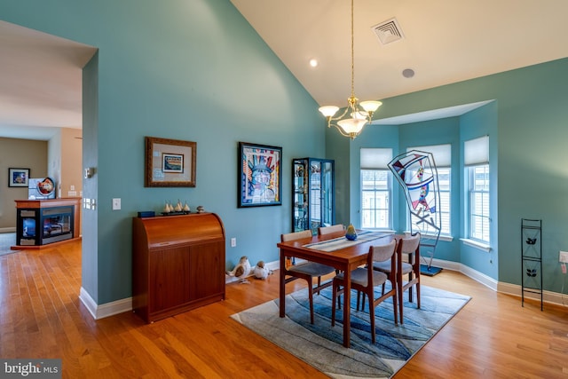 dining area featuring high vaulted ceiling and light hardwood / wood-style floors