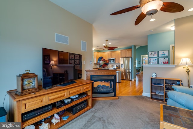 carpeted living room with ceiling fan