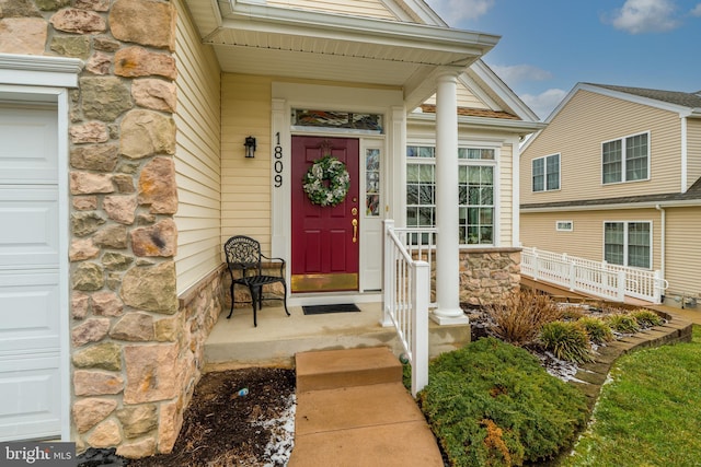 view of exterior entry featuring covered porch