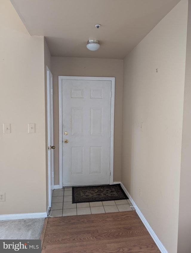 doorway to outside with light tile patterned flooring