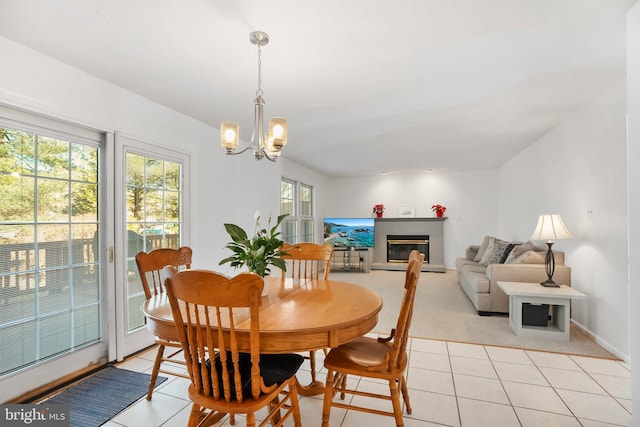 tiled dining space featuring a notable chandelier and a fireplace