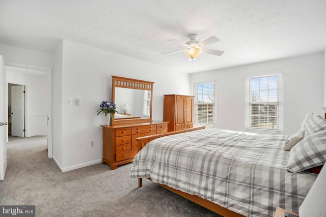 bedroom featuring light carpet, ceiling fan, and a textured ceiling