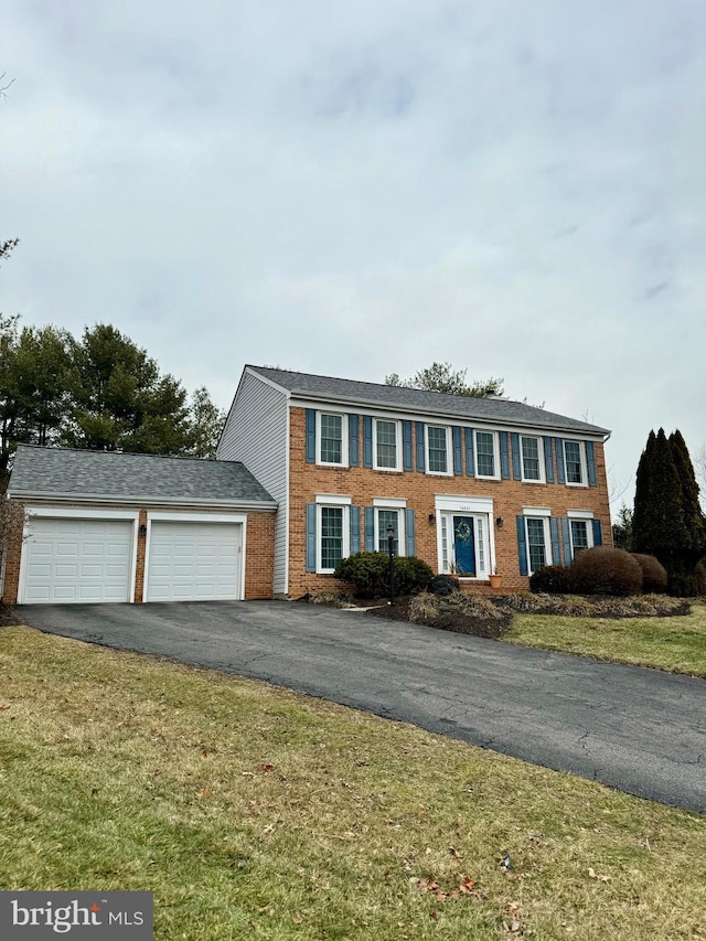 colonial-style house with a garage and a front lawn