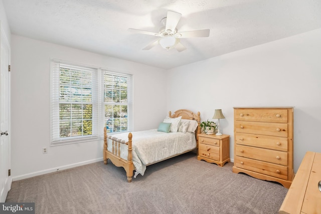 carpeted bedroom with a textured ceiling and ceiling fan