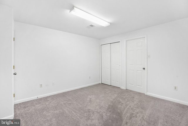 unfurnished bedroom with a closet and light carpet