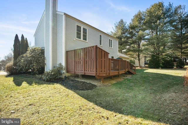 rear view of property with a deck and a lawn