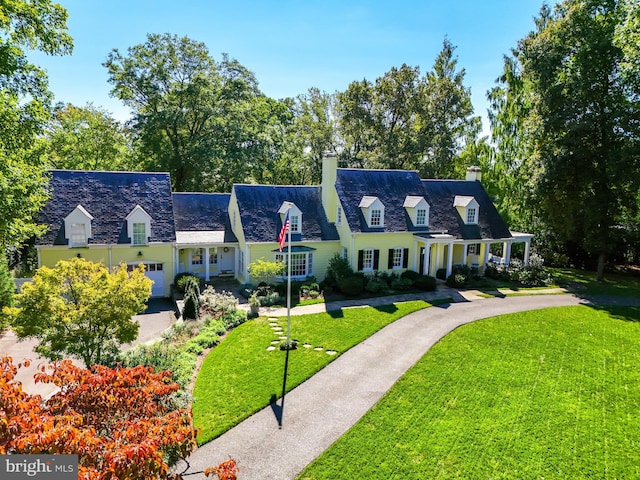 cape cod home with a front yard, driveway, a chimney, and an attached garage