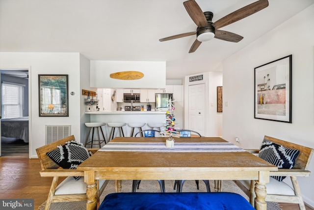 dining space featuring ceiling fan and dark hardwood / wood-style flooring