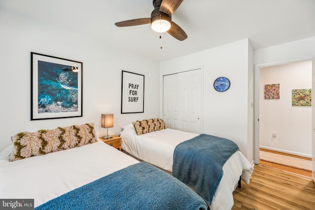 bedroom featuring hardwood / wood-style flooring, ceiling fan, and a closet