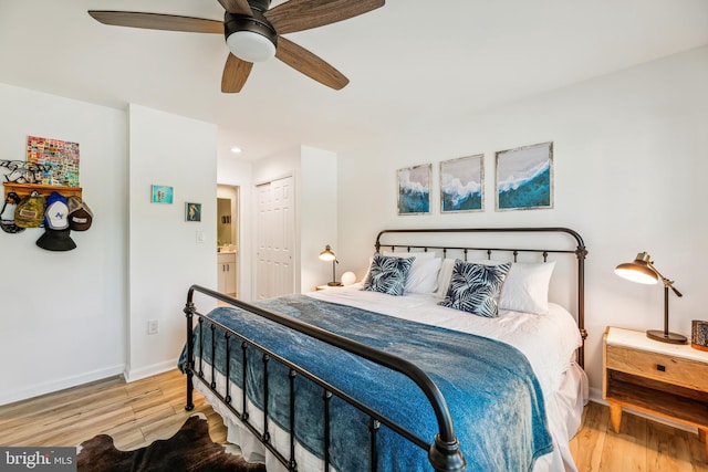 bedroom featuring wood-type flooring, a closet, ceiling fan, and ensuite bathroom