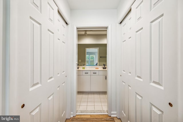 hall with sink and light tile patterned floors