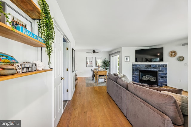 living room featuring ceiling fan and light hardwood / wood-style floors