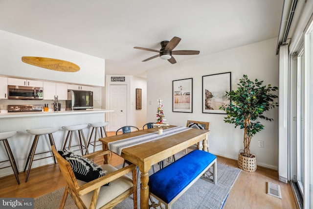 dining room with light hardwood / wood-style flooring and ceiling fan