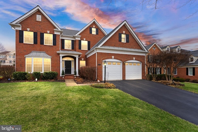 view of front of house featuring a garage and a lawn