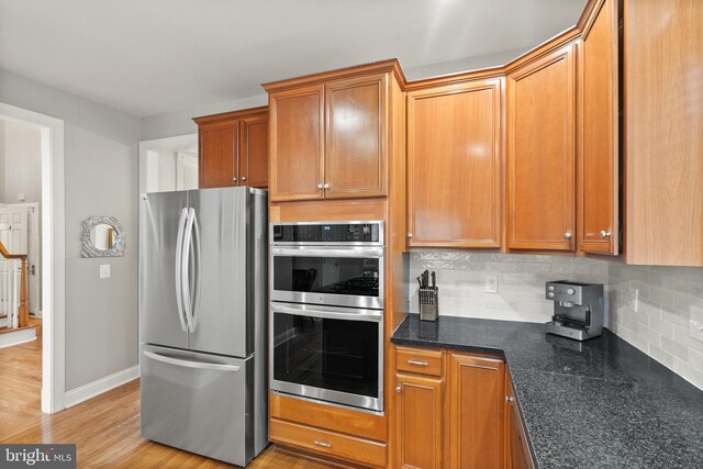 kitchen featuring appliances with stainless steel finishes, light hardwood / wood-style flooring, and backsplash