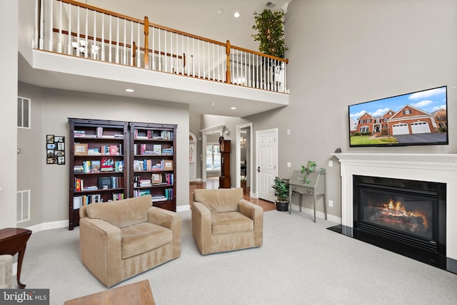 carpeted living room featuring a high ceiling