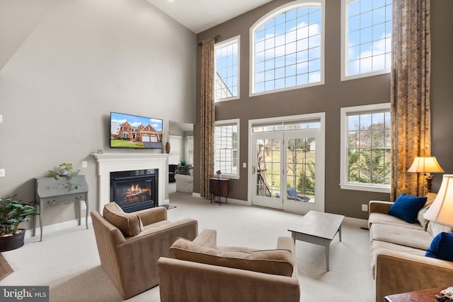 carpeted living room with high vaulted ceiling