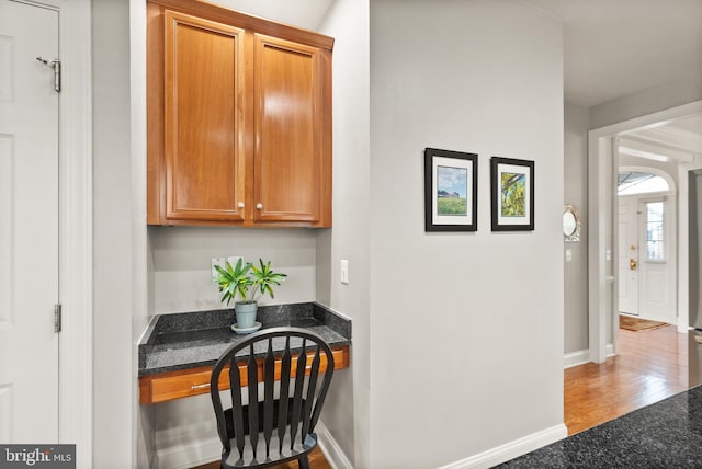 interior space featuring dark stone countertops and built in desk