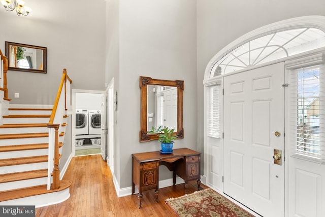 foyer featuring a towering ceiling, light hardwood / wood-style flooring, and independent washer and dryer