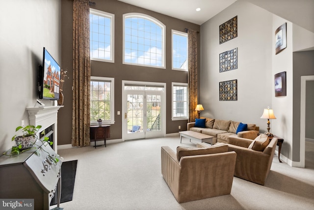 carpeted living room featuring a towering ceiling