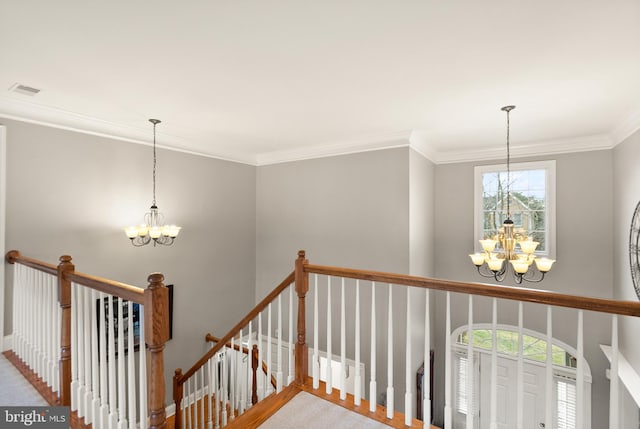 stairway with an inviting chandelier and crown molding