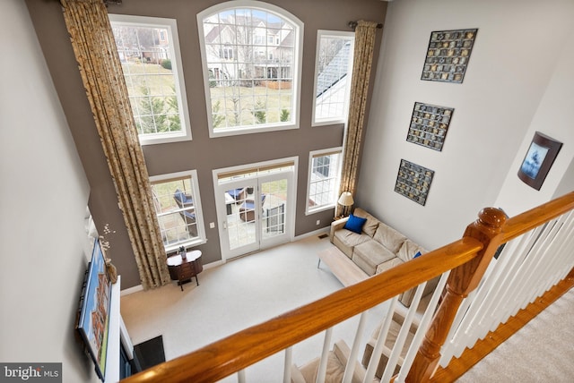 living room with carpet and a towering ceiling