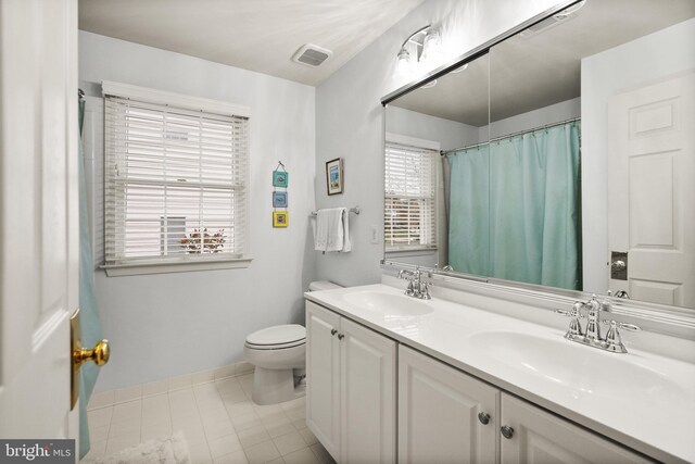 bathroom with tile patterned flooring, vanity, and toilet